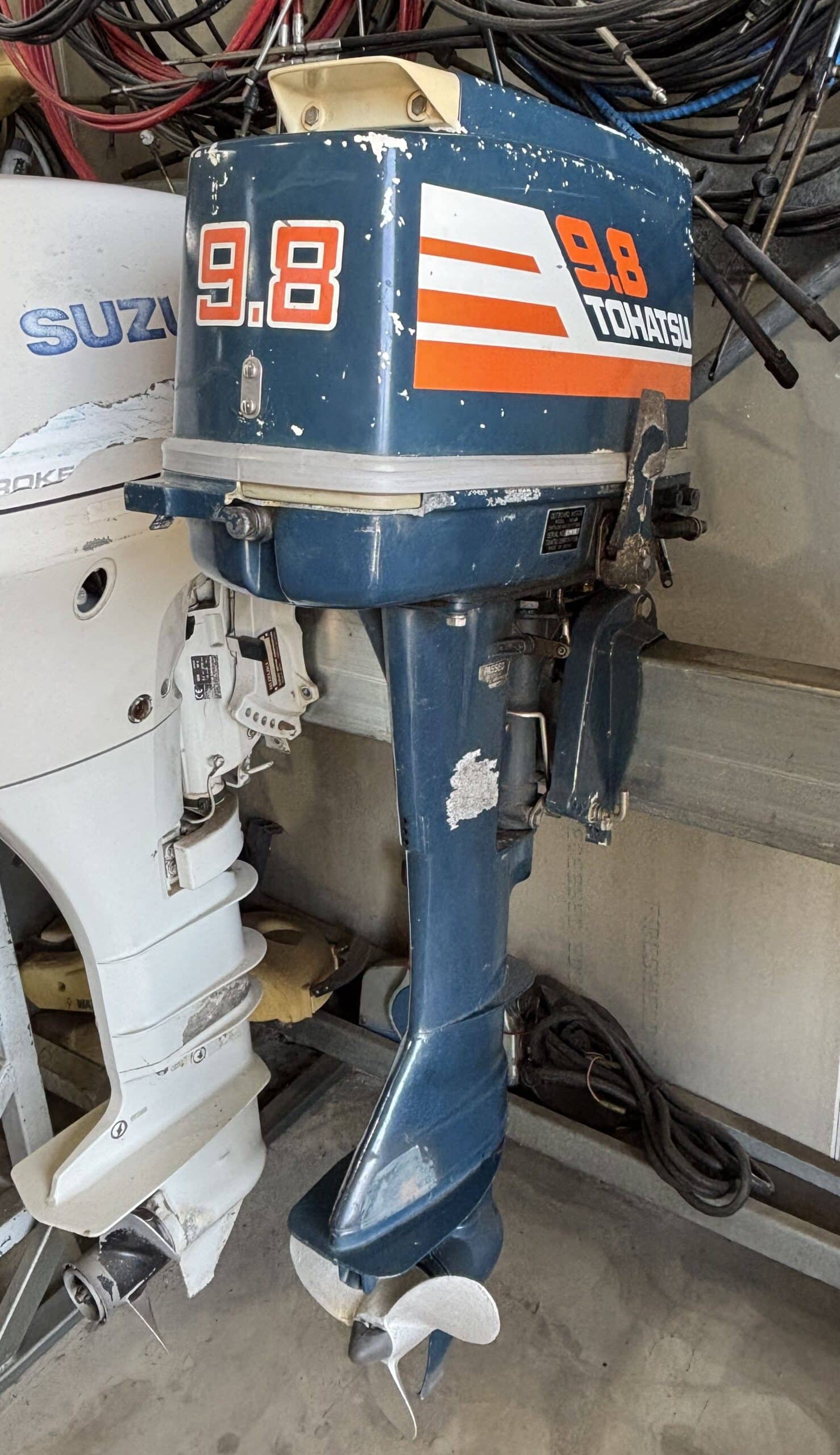 The side of a tohatsu 9.8 horsepower 2 stroke outboard on a motor stand